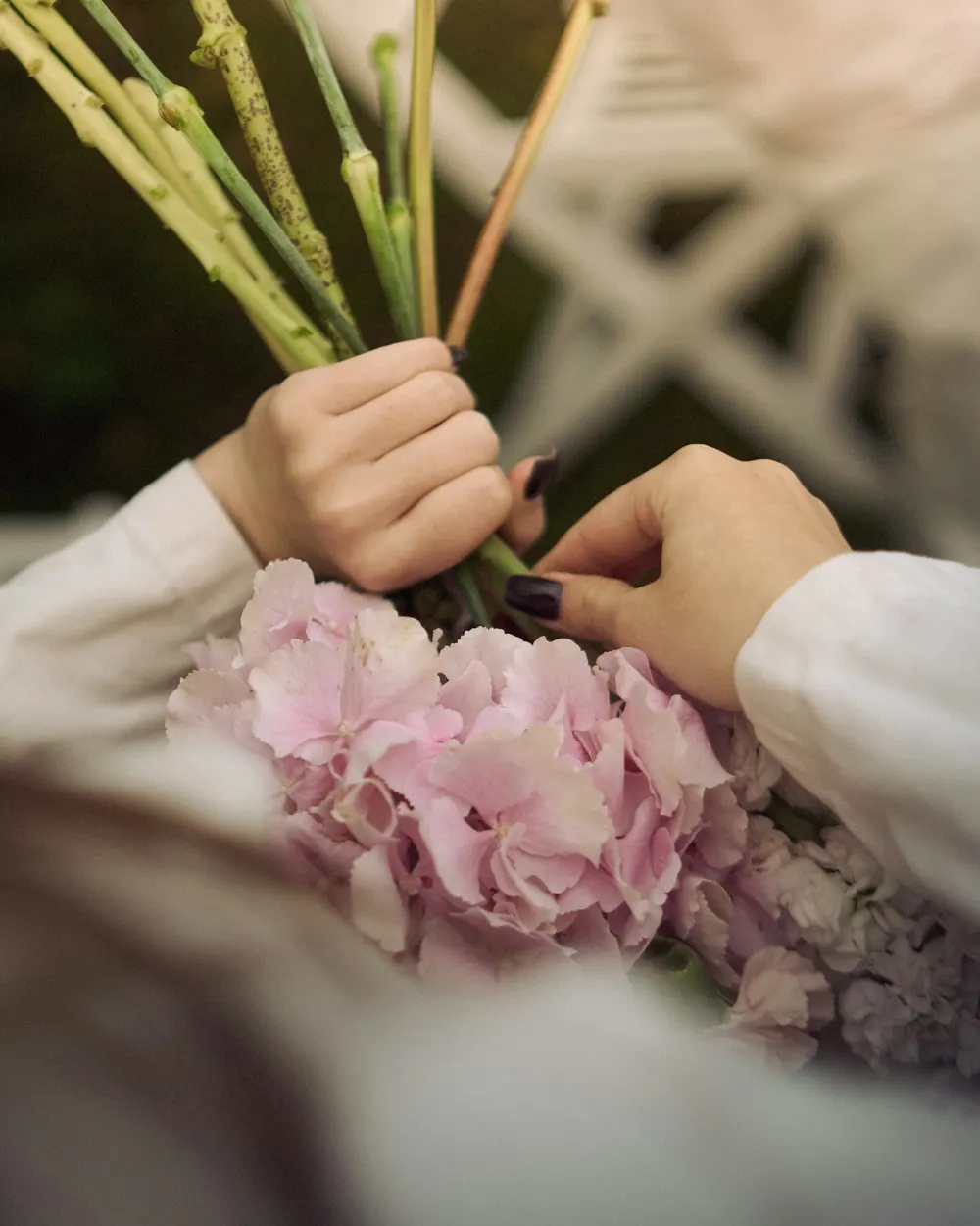Mãos preparando um arranjo de flores para um evento